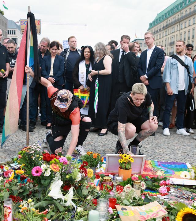 People mourn in front of the Brandenburg Gate after taking part in a mourning march near the scene where a vehicle was driven into a crowd beside the Christopher Street Day (CSD) parade route in Berlin.