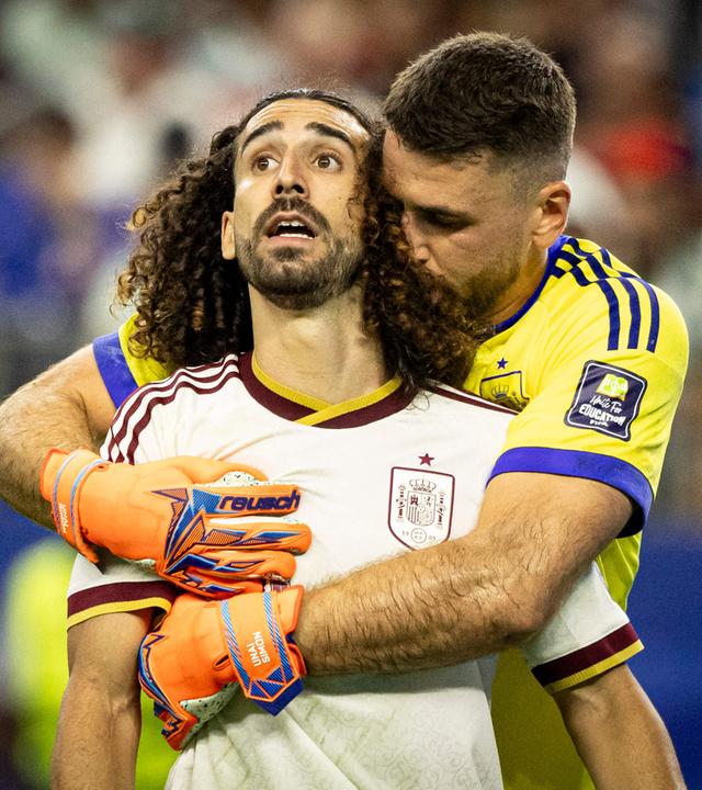 Spaniens Torwart Unai Simón umarmt von hinten Marc Cucurella