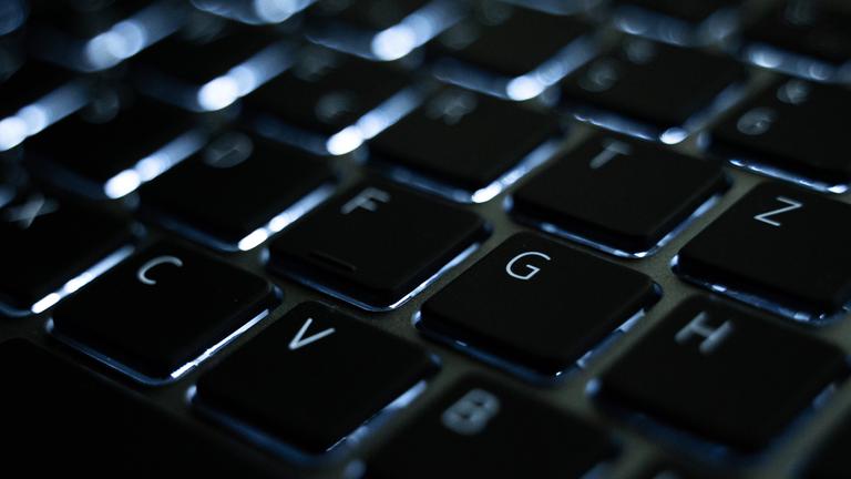 Die beleuchtete Tastatur eines Laptops. 