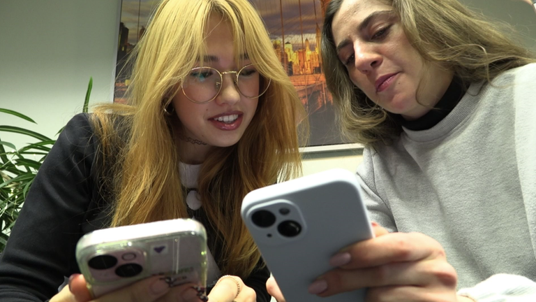 Zwei Mädchen schauen auf ihre Handys