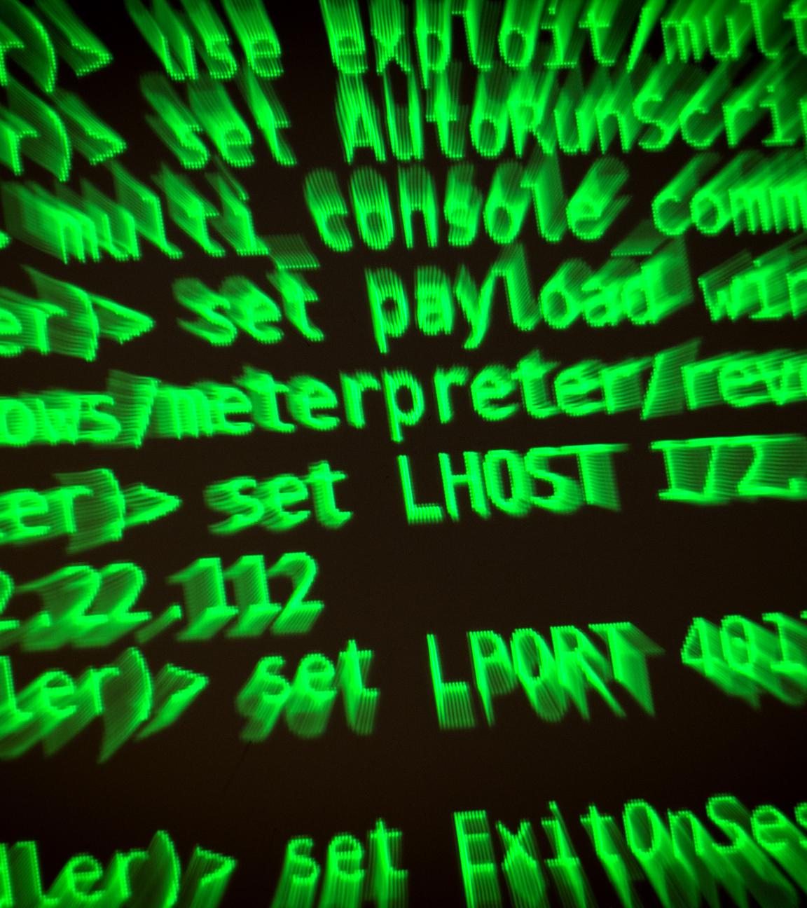 Buchstaben und Zahlen leuchten auf einem Bildschirm, auf dem ein Hacker-Programm geöffnet ist