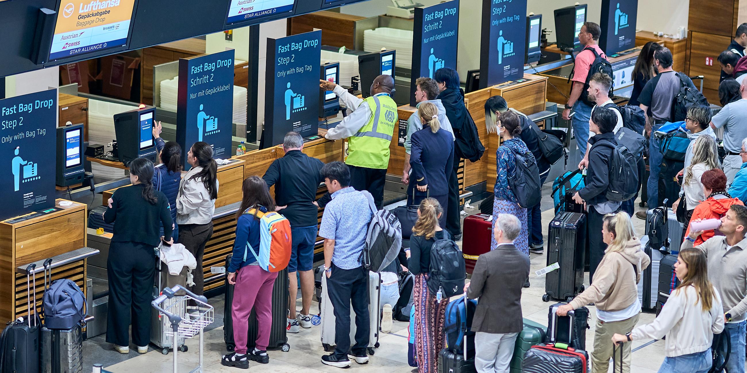 22.09.2025, Brandenburg, Schönefeld: Zahlreiche Fluggäste warten vor den Check-in-Schaltern im Terminal 1 des Flughafens Berlin Brandenburg.