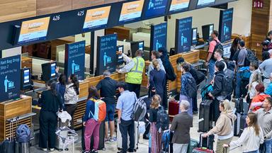 22.09.2025, Brandenburg, Schönefeld: Zahlreiche Fluggäste warten vor den Check-in-Schaltern im Terminal 1 des Flughafens Berlin Brandenburg.