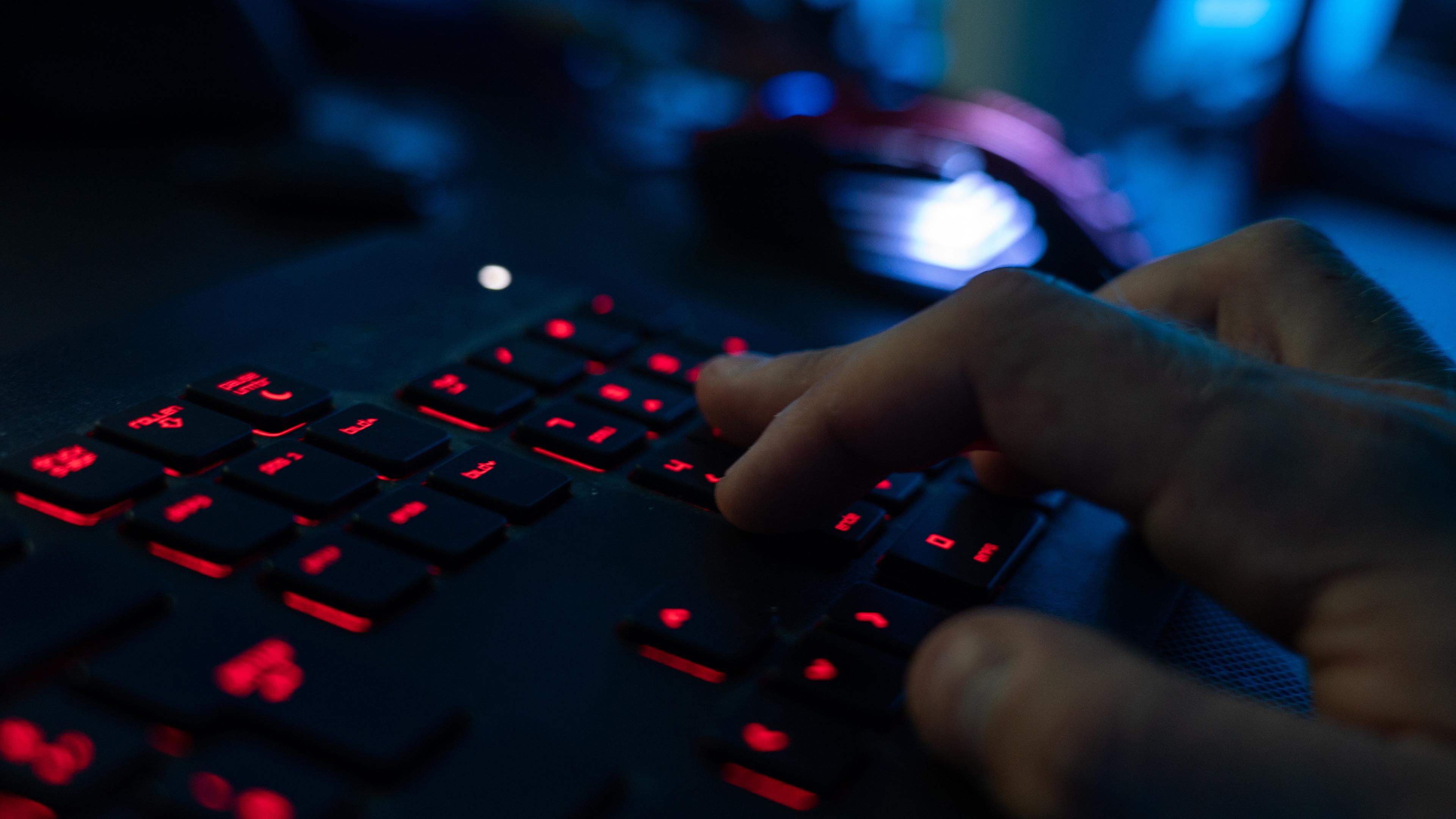 Symbolbild: Ein Mann sitzt am Rechner und tippt auf einer Tastatur. 