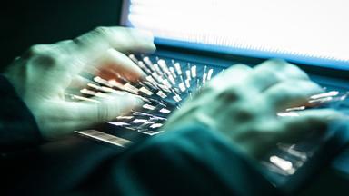 Eine Person tippt mit den Fingern auf einer beleuchteten Laptop-Tastatur. (Symbolbild)