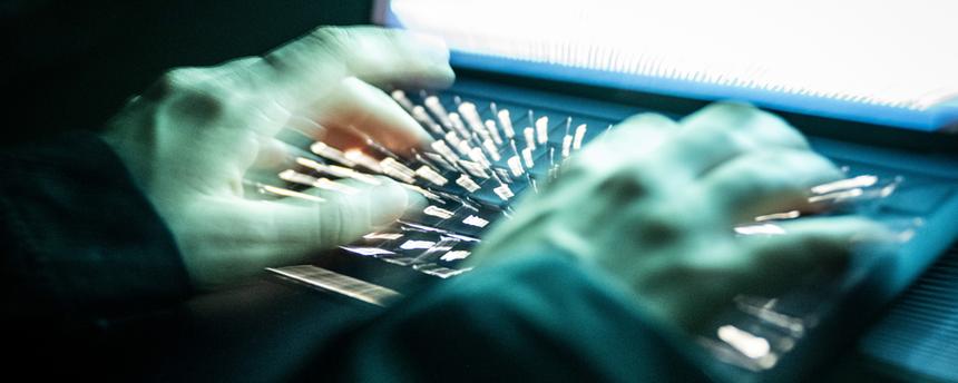 Eine Person tippt mit den Fingern auf einer beleuchteten Laptop-Tastatur. (Symbolbild)