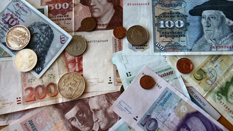 In der Bundesbank-Filiale in Rostock liegen D-Mark-Geldscheine und -Münzen auf dem tisch. 