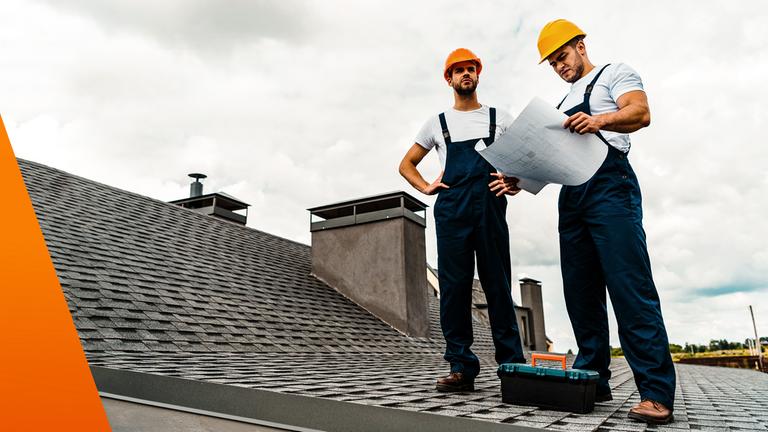 Zwei Männer überprüfen ein Dach eines Hauses
