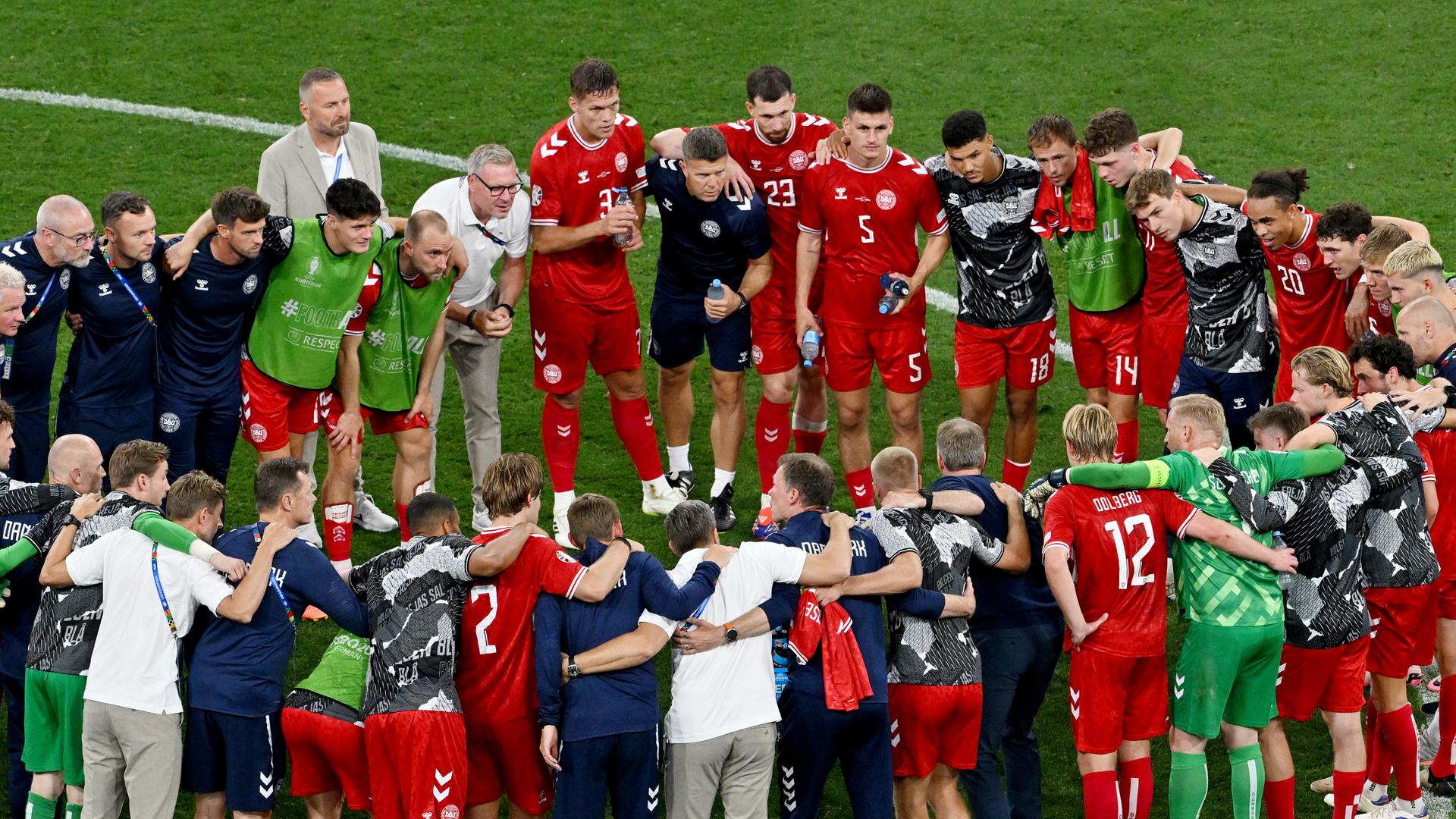 Die Spieler, Trainer und Betreuer der dänischen Nationalmannschaft stehen nach dem Spiel gegen Serbien in einem Teamkreis zusammen. 