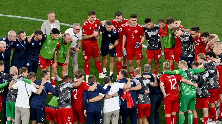 Die Spieler, Trainer und Betreuer der dänischen Nationalmannschaft stehen nach dem Spiel gegen Serbien in einem Teamkreis zusammen. 