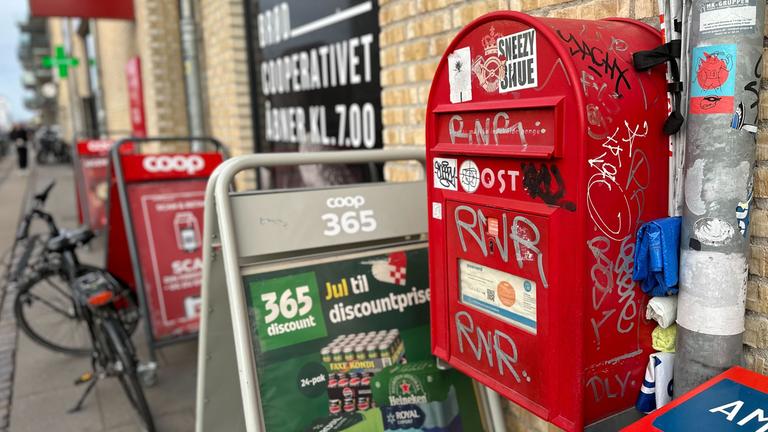 Ein Briefkasten hängt vor einem Kiosk in Kopenhagen