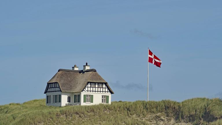 Dänisches Haus mit gehisster Dänemark-Fahne