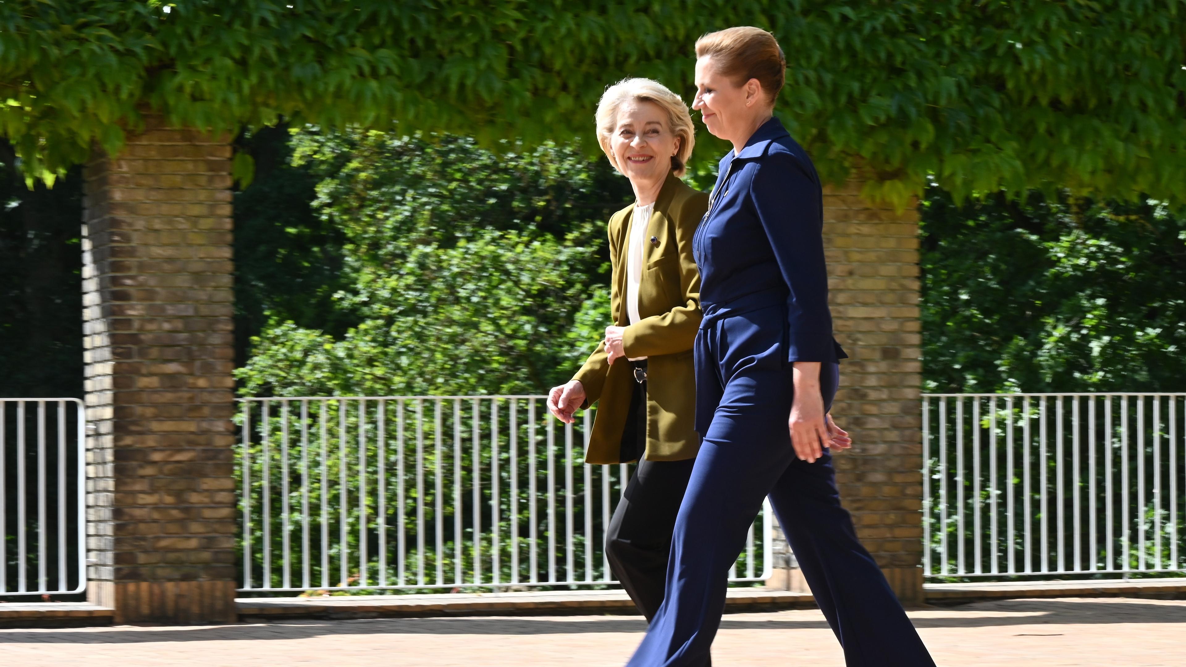 Ursula von der Leyen (l), EU-Kommissionspräsidentin, und Mette Frederiksen, Ministerpräsidentin von Dänemark, gehen nebeneinander vor der Universität.
