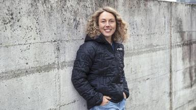 Laura Dahlmeier Laura Dahlmeier lehnt an einer grauen Mauer und lächelt in die Kamera. 