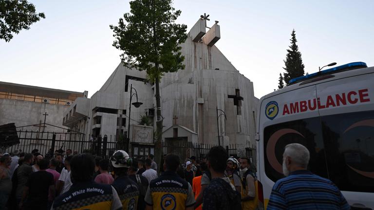 Menschen und Rettungskräfte versammeln sich am Ort eines gemeldeten Selbstmordanschlags auf die Sankt-Elias-Kirche im Damaskuser Stadtteil Dwelaa am 22. Juni 2025.