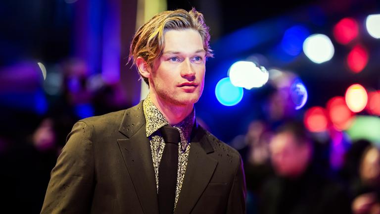 Schauspieler Damian Hardung steht am Eröffnungsabend der Berlinale auf dem roten Teppich vor dem Berlinale Palast.