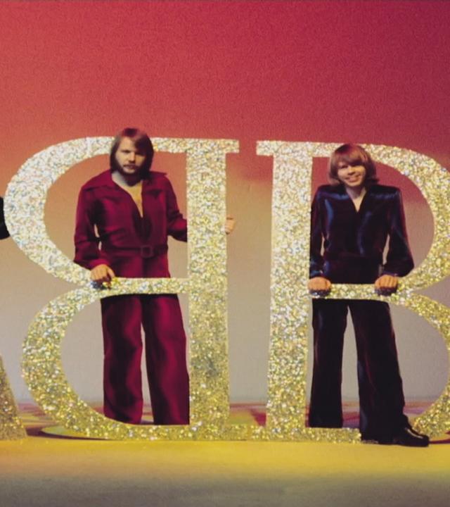 Die Bandmitglieder posieren mit dem ABBA-Logo