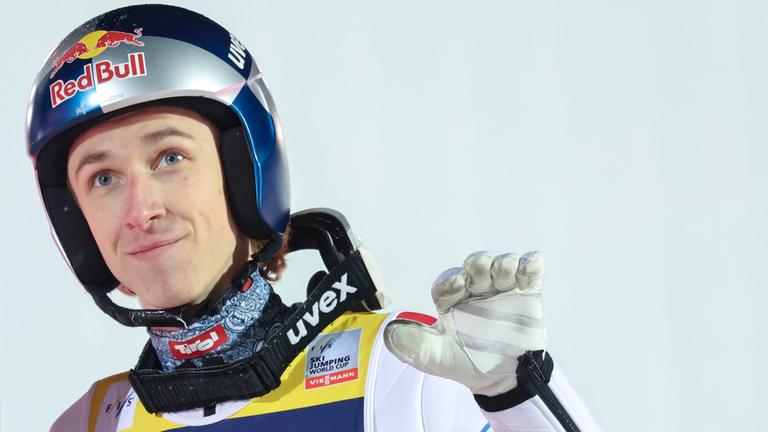 Daniel Tschofenig macht beim Weltcup-Skispringen in Lillehammer mit der linken Hand eine Handbewegung