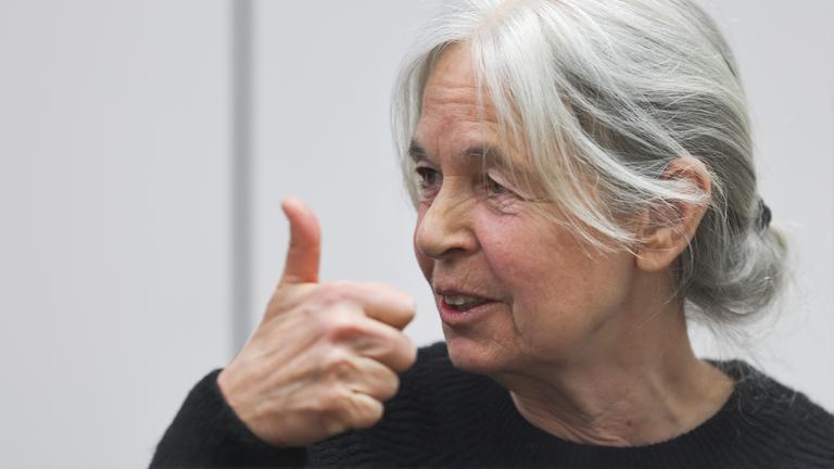 Daniela Klette hält im Oberlandesgericht Celle im Gerichtssaal den rechten Daumen hoch. Die Ermittler werfen Klette versuchten Mord, unerlaubten Waffenbesitz sowie versuchten und vollendeten schweren Raub vor