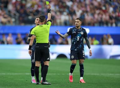 Schiedsrichter Danny Makkelie (vorn) zeigt dem paraguayischen Spieler Miguel Almiron (hunten) die Gelbe Karte.