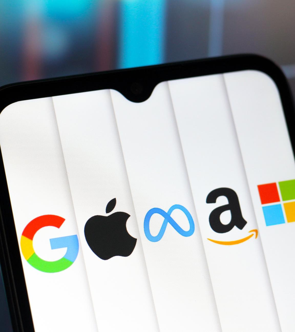 Auf dem Bildschirm eines Handys sind die Logos der fünf bekanntesten Tech-Unternehmen abgebildet.