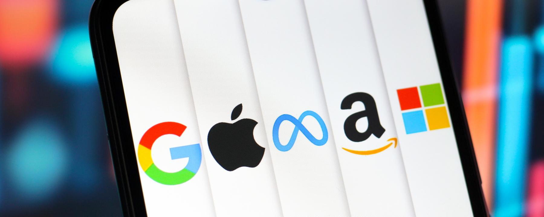 Auf dem Bildschirm eines Handys sind die Logos der fünf bekanntesten Tech-Unternehmen abgebildet.