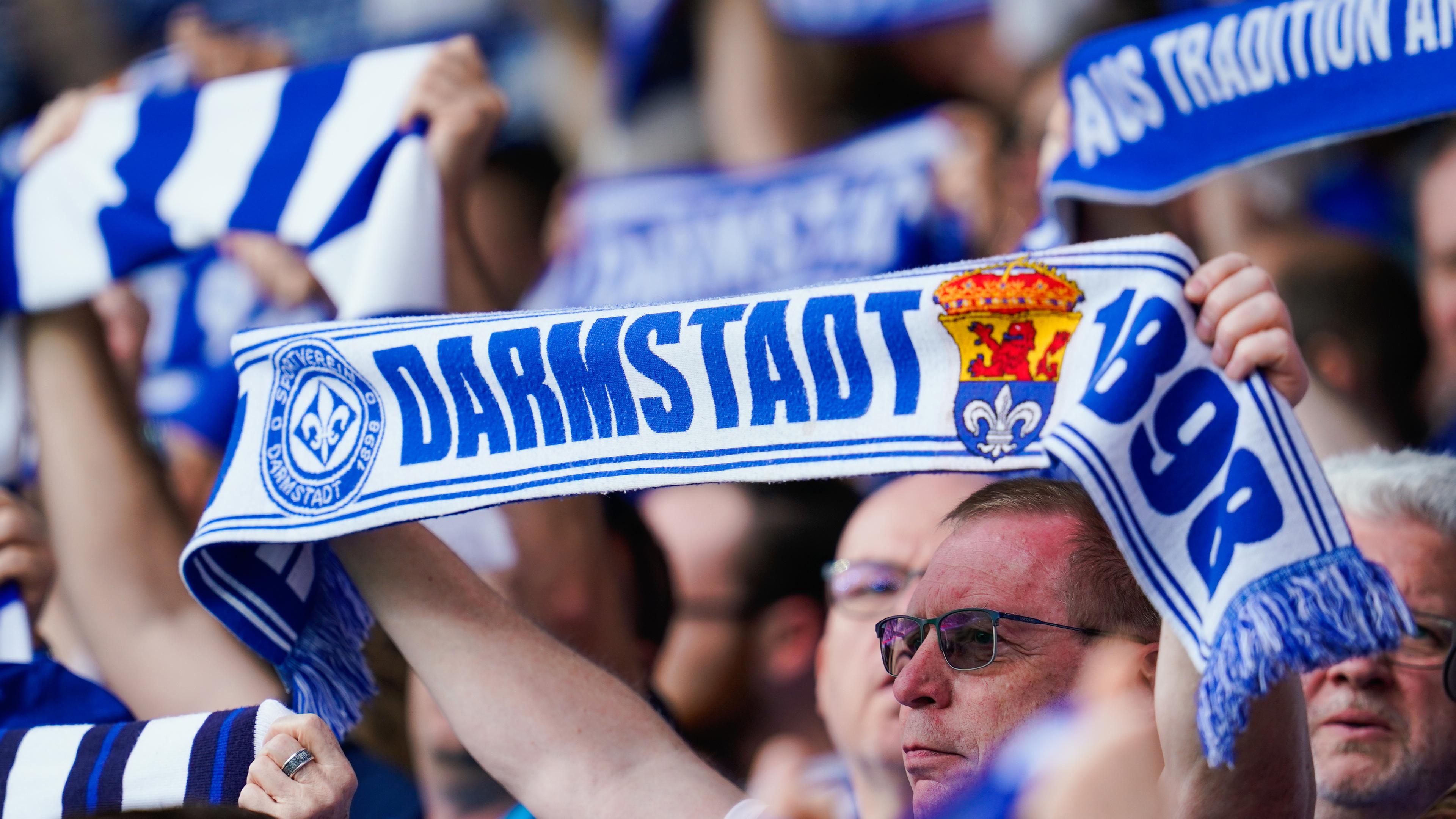 Darmstadt Fans halten Fanschals in die Höhe.