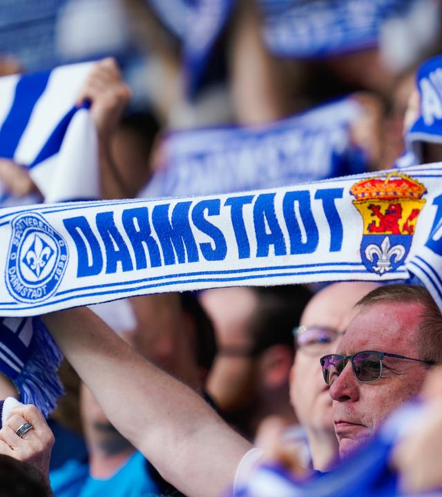 Darmstadt Fans halten Fanschals in die Höhe.