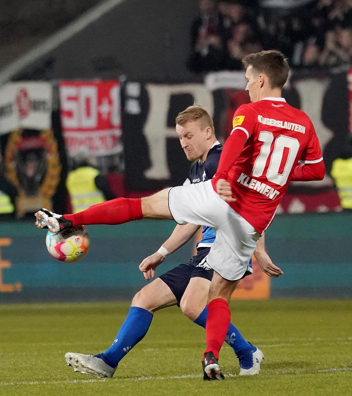 18.03.2023, Hessen, Darmstadt: Fußball: 2. Bundesliga, Darmstadt 98 - 1. FC Kaiserslautern, 25. Spieltag, Merck-Stadion am Böllenfalltor. Fabian Holland (hinten) von Darmstadt und Philipp Klement von Kaiserslautern kämpfen um den Ball.