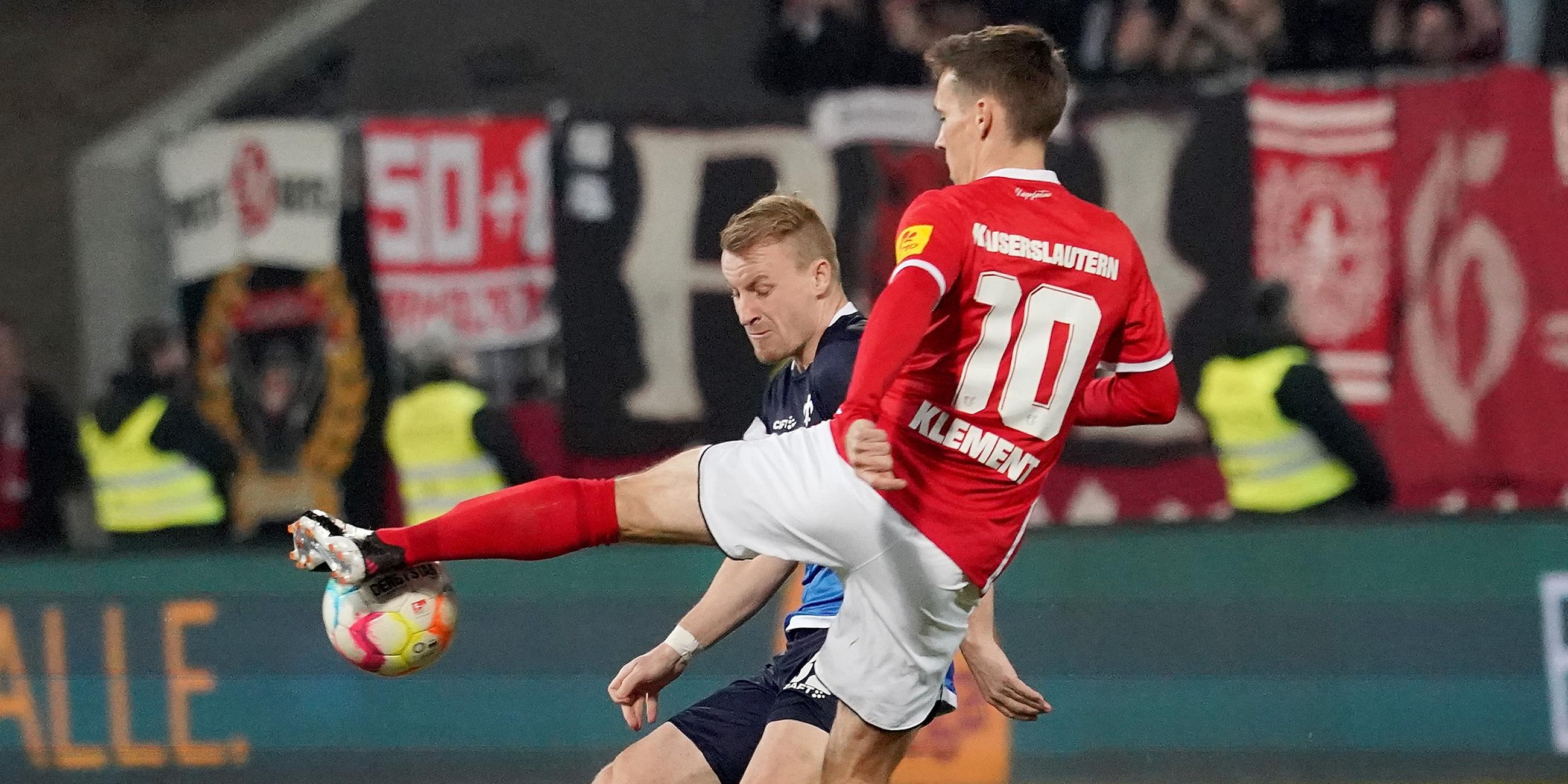 18.03.2023, Hessen, Darmstadt: Fußball: 2. Bundesliga, Darmstadt 98 - 1. FC Kaiserslautern, 25. Spieltag, Merck-Stadion am Böllenfalltor. Fabian Holland (hinten) von Darmstadt und Philipp Klement von Kaiserslautern kämpfen um den Ball.