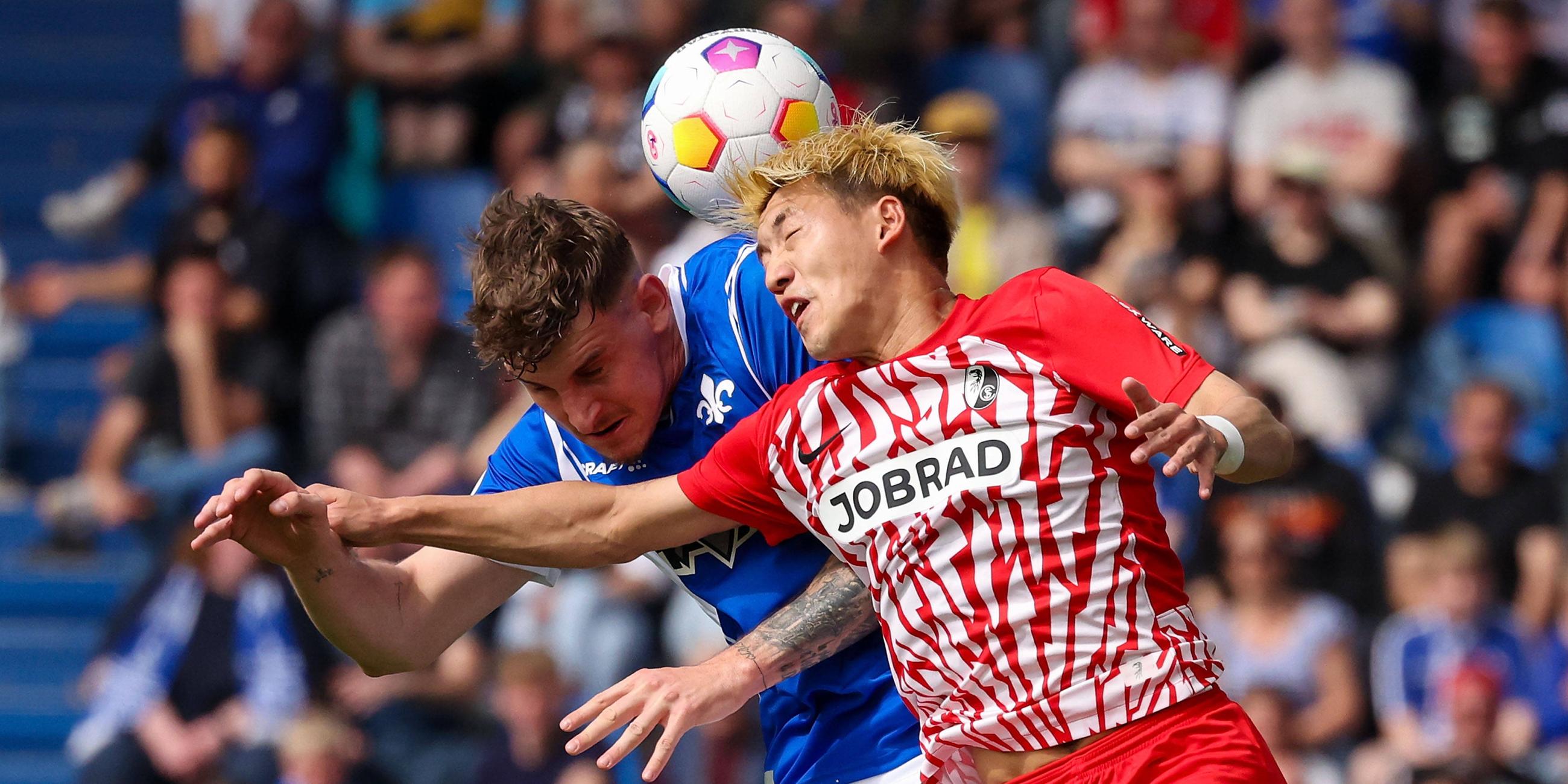  Kopfballduell zwischen Matej Maglica (SV Darmstadt 98) und Ritsu Doan (SC Freiburg).