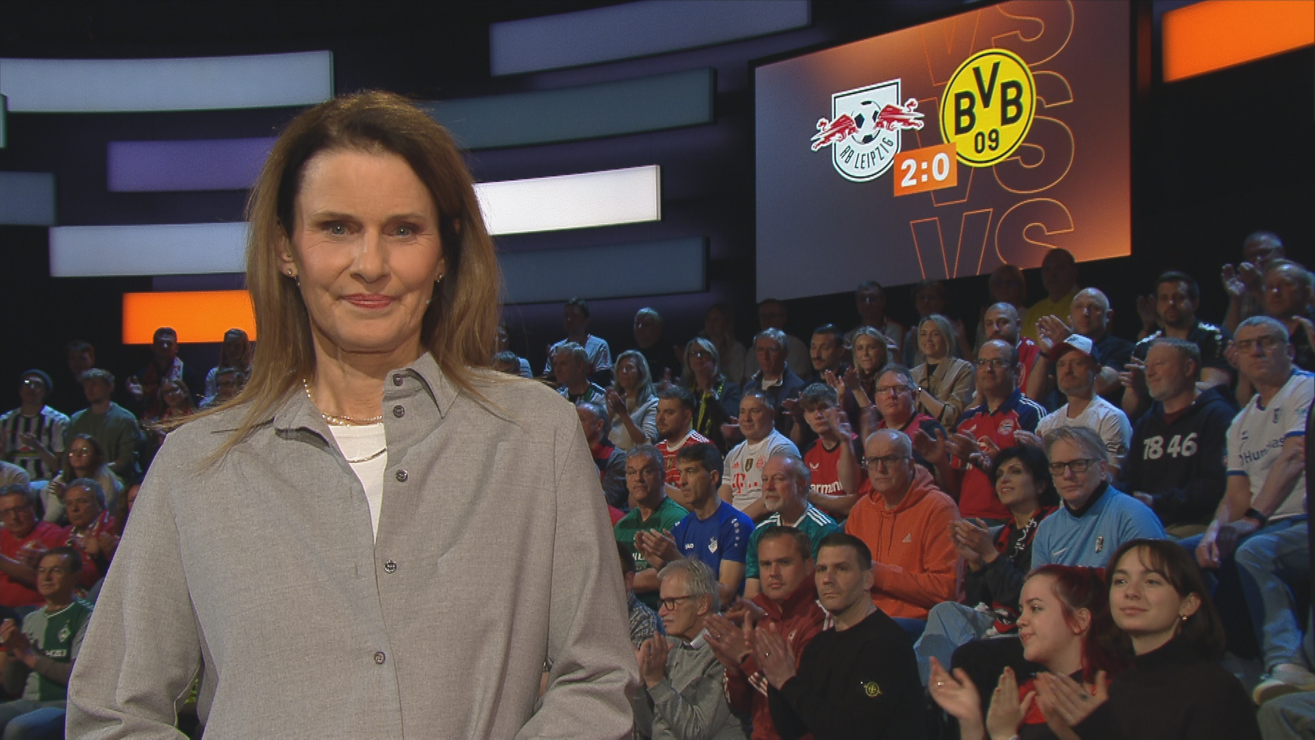 Moderatorin Katrin Müller-Hohenstein im aktuellen Sportstudio, mit dem Topspiel im Hintergrund.