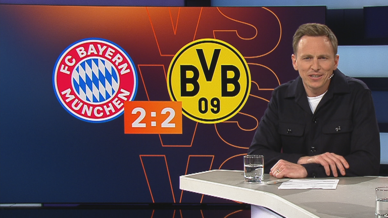 Der Moderator Jochen Breyer im aktuellen Sportstudio. Im Hintergrund das Topspiel zwischen Bayern München und Borussia Dortmund.