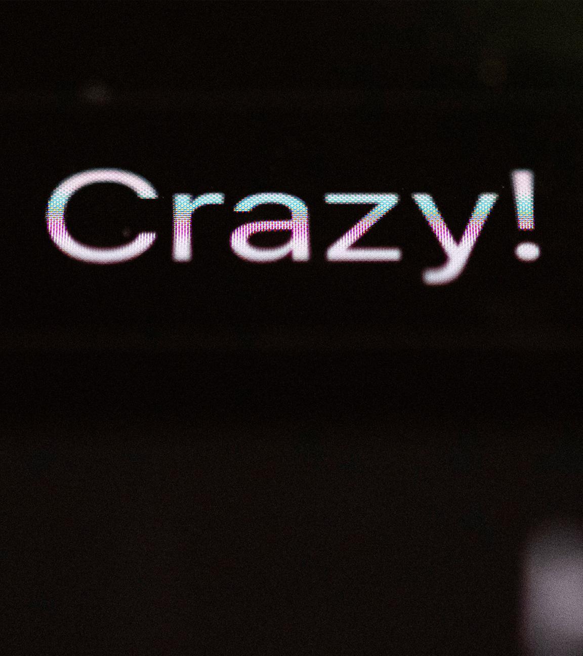 Die Worte Das Crazy! sind auf dem Display eines Smartphones zu sehen.