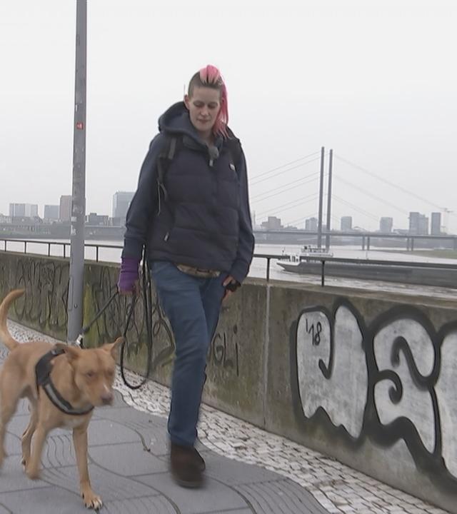 Nicki geht mit ihrem Hund Snoopy an der Rheinpromenade entlang. 