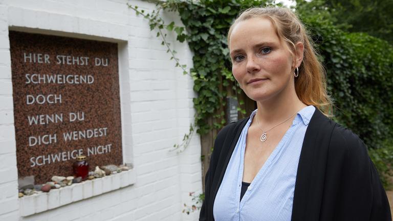 Maria Holzgrewe vor der Gedenktafel im Rosengarten der Gedenkstätte "Bullenhuser Damm" in Hamburg.