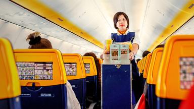 Flugbegleiterin in einem Ryanair-Flugzeug bei der Arbeit mit Verkaufswagen.