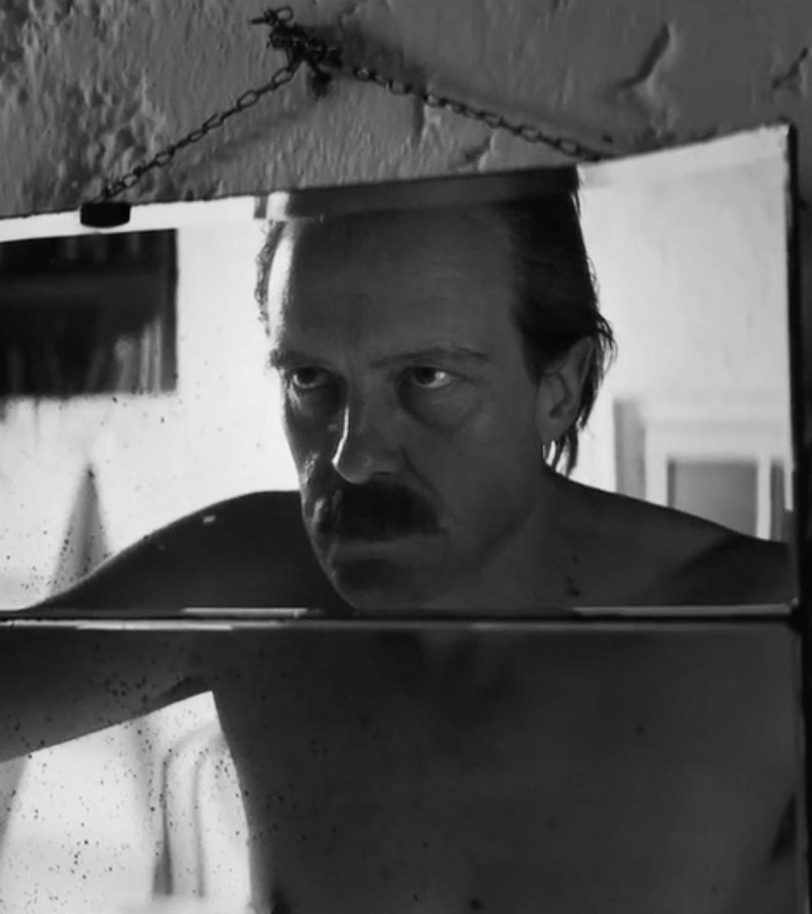 August Diehl steht in der Rolle des Josef Mengele vor einem Spiegel.