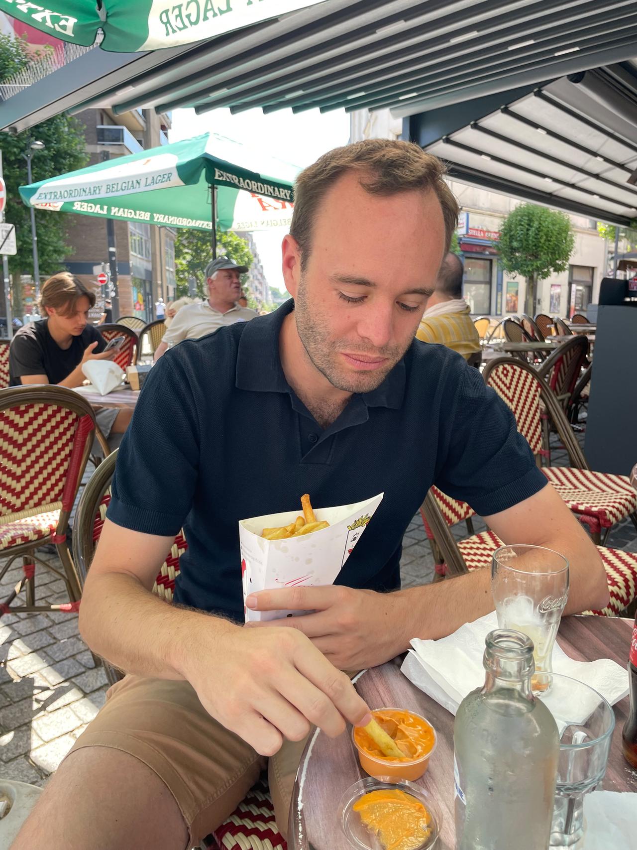 David aus Deutschland tunkt seine Pommes Frites in eine traditionell belgische Pommes-Sauce.