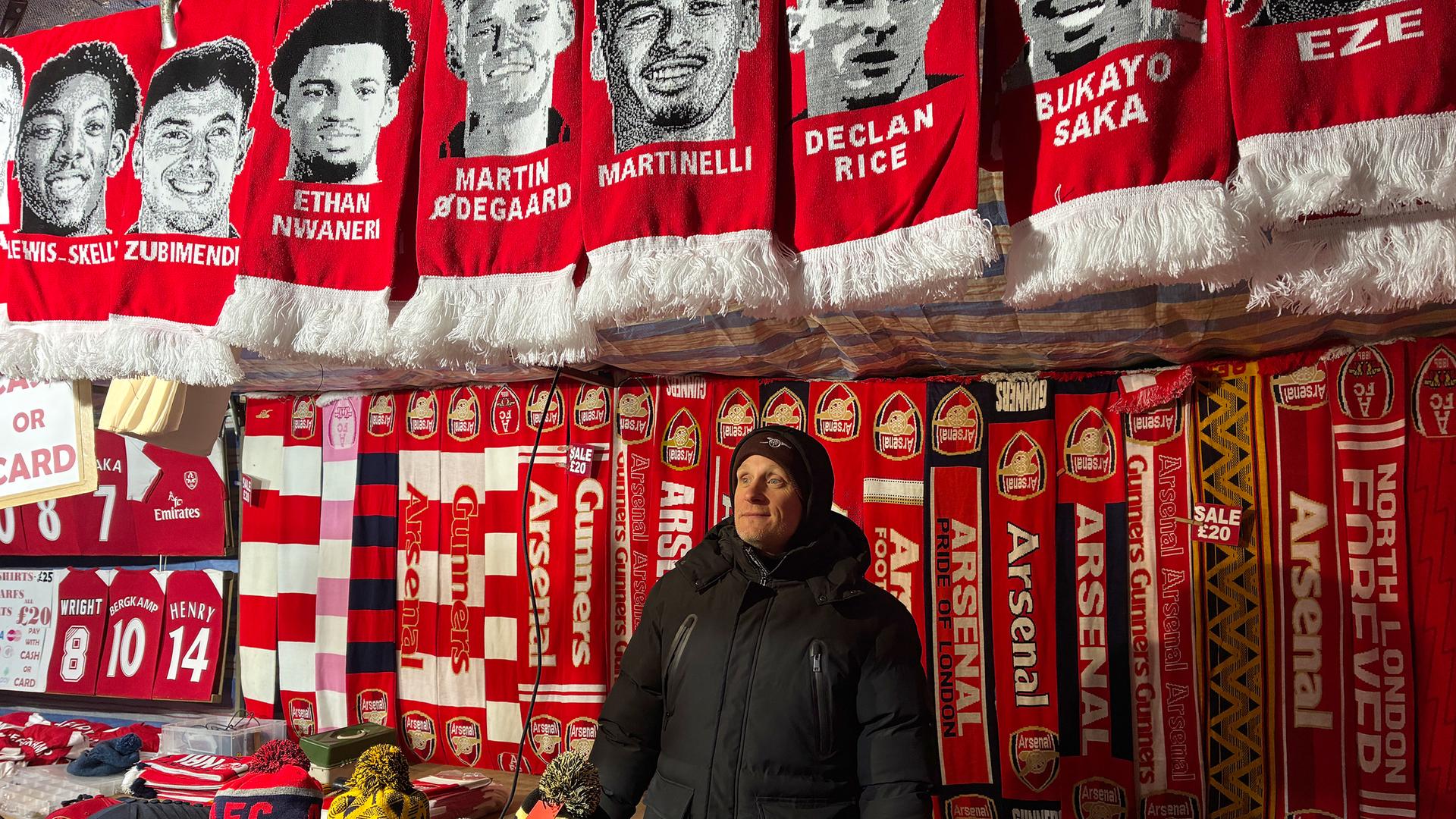 David verkauft vor dem Stadion Arsenal-Fanartikel.