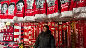 David sells Arsenal merchandise in front of the stadium.