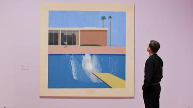 Ein Mitarbeiter betrachtet das Werk „A Bigger Splash“ bei der Vorbesichtigung der Retrospektive über das Werk von David Hockney in der Tate Britain, in London, im Jahre 2017.