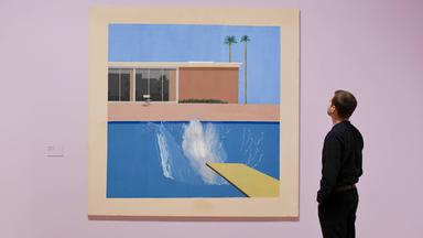 Ein Mitarbeiter betrachtet das Werk „A Bigger Splash“ bei der Vorbesichtigung der Retrospektive über das Werk von David Hockney in der Tate Britain, in London, im Jahre 2017.