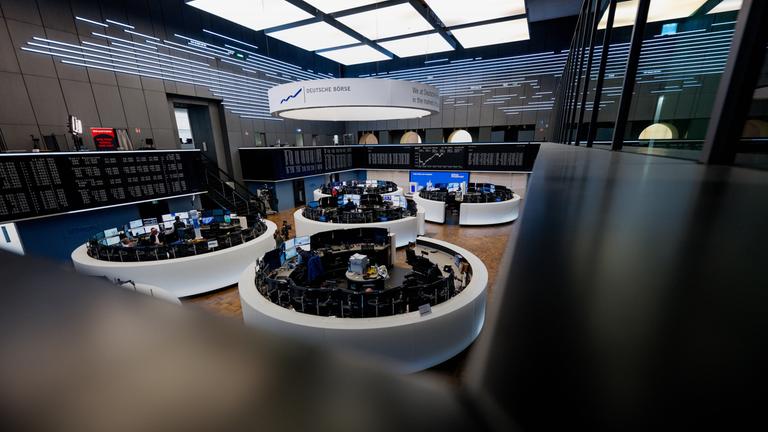 Auf einer Anzeigetafel wird die Kurve des deutschen Aktienindex (DAX) in der Frankfurter Börse im Hintergrund dargestellt.