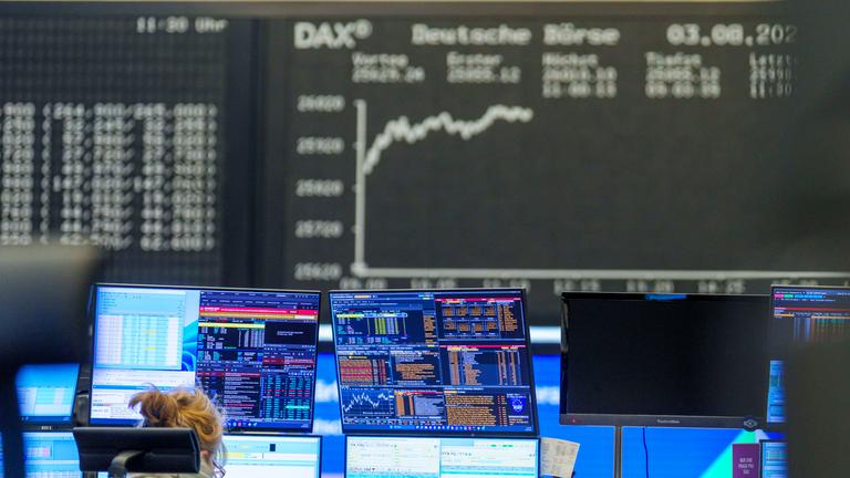 Eine Händlerin sitzt im Handelssaal in Frankfurt vor ihren Bildschirmen.
