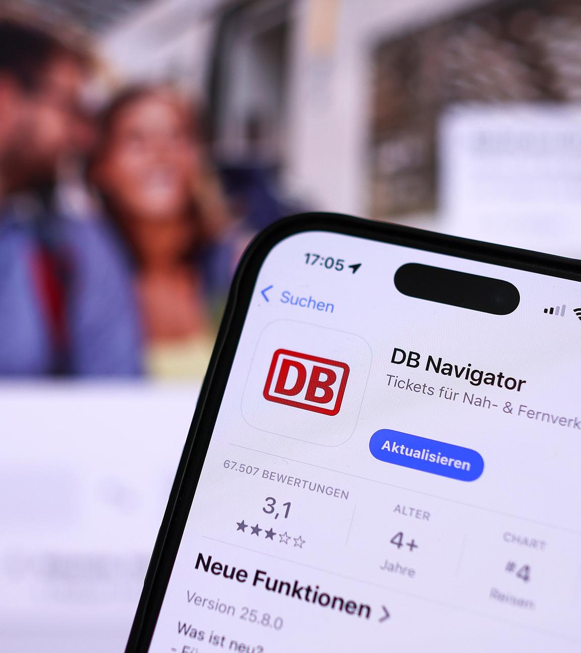 Eine Hand hält ein Mobiltelefon mit der App DB-Navigator im App-Store