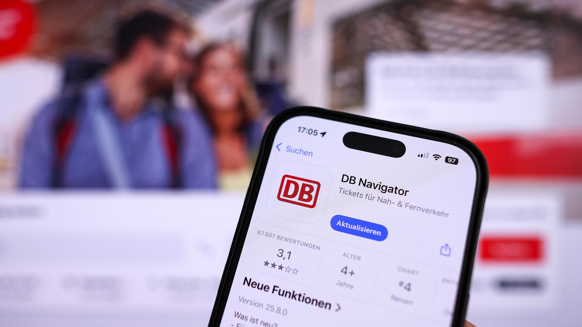 Eine Hand hält ein Mobiltelefon mit der App DB-Navigator im App-Store