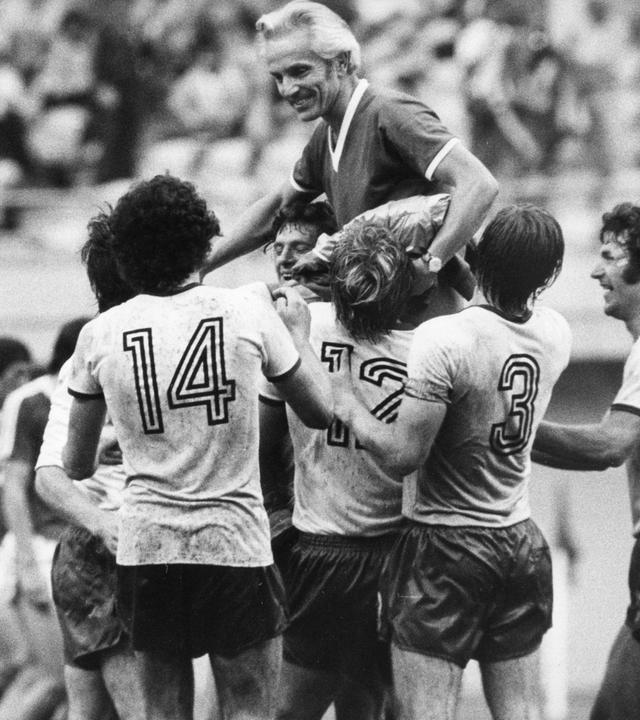 Die DDR-Spieler Hartmut Schade (14), Gerd Kische (12), Hans-Jürgen Dörner (3) und Wolfram Löwe (13) bejubeln bei Spielende ihren Trainer Georg Buschner (oben) und tragen ihn auf den Schultern. Die DDR-Elf gewinnt am 27.7.1976 in Montreal das Halbfinale des Olympischen Fußballturniers gegen die UdSSR mit 2\1 und steht damit im Endspiel, das vier Tage später mit 3\1 gegen Polen gewonnen wird. 