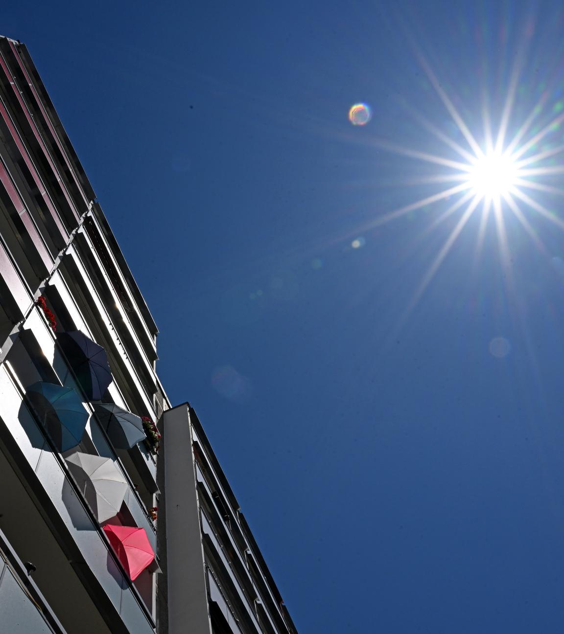 Thüringen, Jena: Mit Sonnenschirmen schützen Bewohner in einem Plattenbau in Jena-Lobeda die Wohnung vor der Hitze.