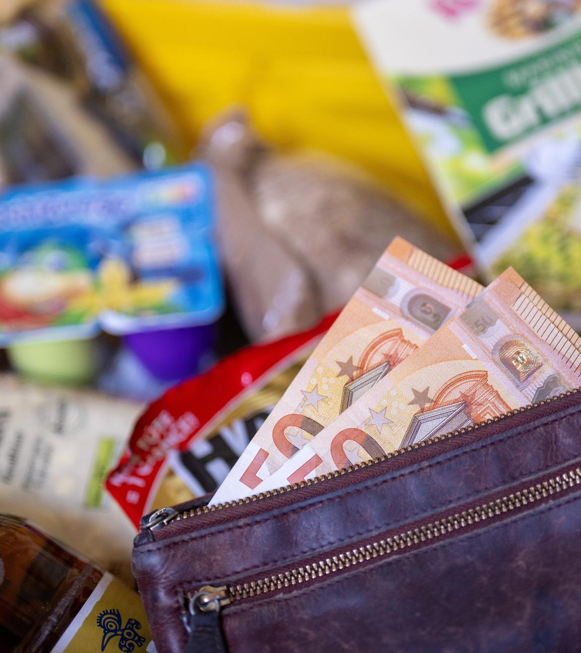 Berlin: Ein Geldbeutel gefüllt mit Geldscheinen liegt nach dem Einkauf in einem mit diversen Lebensmitteln gefüllten Einkaufskorb. 